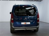 the rear end of a blue van parked in a garage
