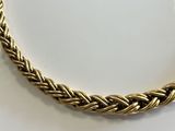 a close up of a gold necklace on a white surface