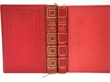 un vieux livre à la couverture rouge et à la bordure dorée