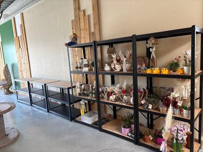 a room with a lot of shelves with flowers and vases on them