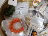 a wooden bowl filled with assorted jewelry and other items