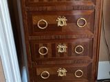 a wooden chest of drawers with a clock on top of it