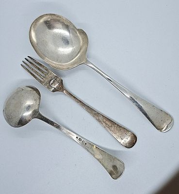 three silver spoons and two silver spoons on a white table