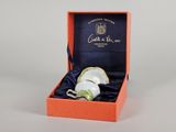 une boîte orange contenant une tasse à thé et une soucoupe