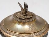 a gold plate with a bird on top of it
