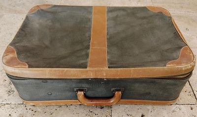 une valise posée par terre, sur le sol