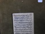 arabic writing on a piece of paper on a wall