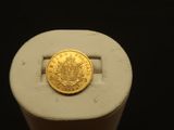 une pièce d'or posée sur un objet blanc