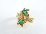 an image of a gold ring with a green stone surrounded by diamonds