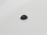 a green tourmaline gemstone on a white surface