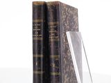 two books are stacked on top of each other on a white surface