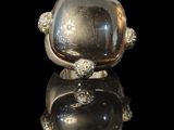 silver plated ring with a large glass stone in the middle of it