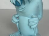 une statue bleue représentant un personnage de dessin animé, posée sur une assiette