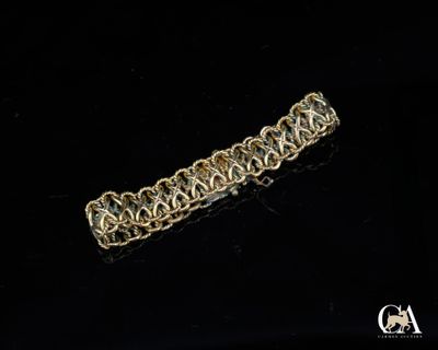 gros plan d'un bracelet en chaîne en or sur une surface noire