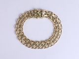 a gold chain bracelet on a white surface