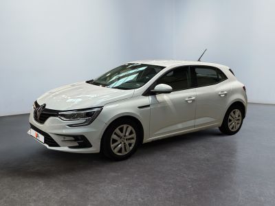 Une voiture blanche est garée dans une pièce au sol gris.