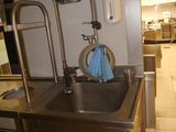 a stainless steel sink with a faucet and soap dispenser