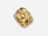 a close up of a gold ring with a black stone