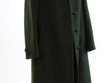 un manteau vert sur un mannequin, sur fond blanc