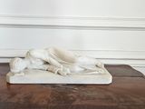 statue en marbre représentant un chien posé sur une table dans une pièce