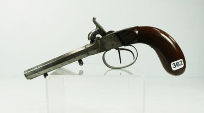 un vieux pistolet à crosse en bois exposé dans une vitrine