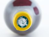 a close up of a bottle of wine with a yellow cap