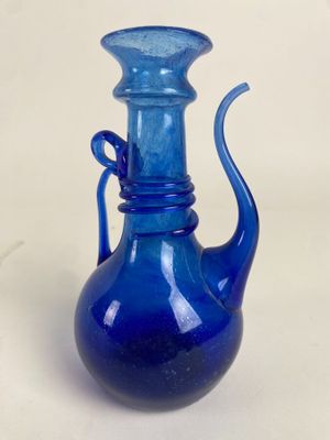 un vase en verre bleu posé sur une table