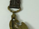 a metal bird with a leather strap hanging from it ' s back