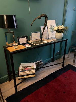 une table avec des livres et une lampe dans une pièce