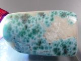 a blue and white stone with a red light on it