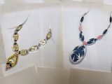 two necklaces with different designs on them on a table