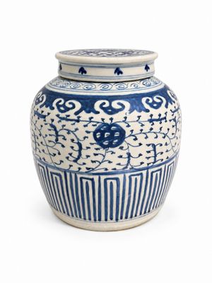 un vase bleu et blanc avec un couvercle, posé sur une surface blanche