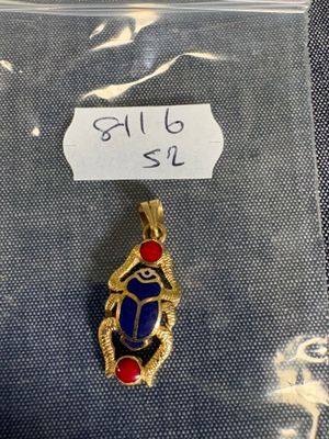 un pendentif en or orné d'une pierre bleue et rouge
