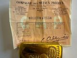 un lingot d'or posé sur une feuille de papier accompagnée d'un reçu