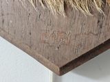 a close up of a piece of wood with some grass on it