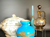 three vases on a table with a candle in the background