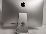 a silver apple computer with a power cord attached to it