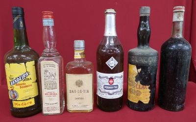 several bottles of alcohol are lined up on a red table