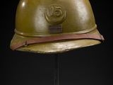 an old helmet on a metal stand with a black background