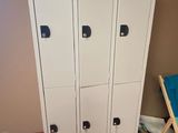 a picture of a white locker in a room with a blue chair