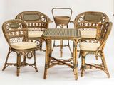 une photo représentant un ensemble composé de quatre chaises en osier et d'une table