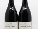 deux bouteilles de vin posées l'une à côté de l'autre sur une surface blanche