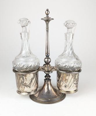 trois carafes en verre posées sur un plateau en argent orné d'une bougie