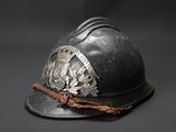 an old fireman ' s helmet with the emblem of a coat of arms