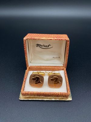 a close up of a pair of gold cufflinks in a box