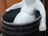 a white statue of a bear sitting in a barrel