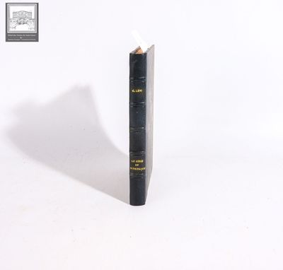 an old book with a pencil sticking out of it on a white surface