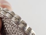 a person holding a silver watch in their hand
