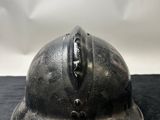 an old fireman ' s helmet is sitting on a black surface