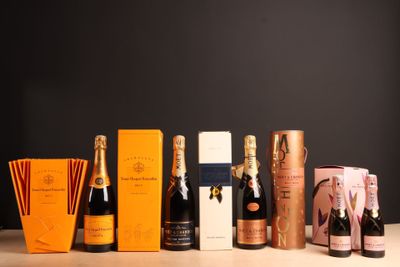 plusieurs bouteilles de champagne posées sur une table, à côté d'une boîte de chocolats